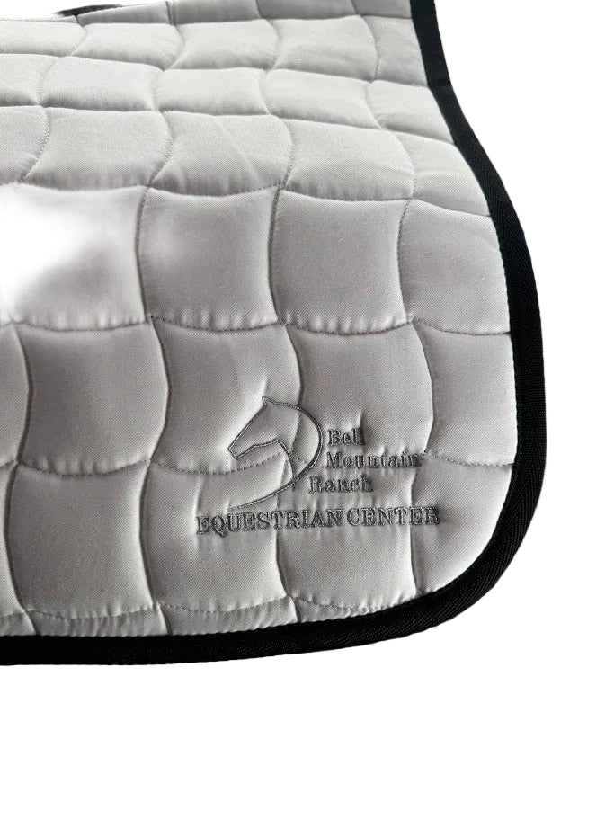 Contoured English Saddle Pad with Bell Mountain Logo. White with silver stitching.